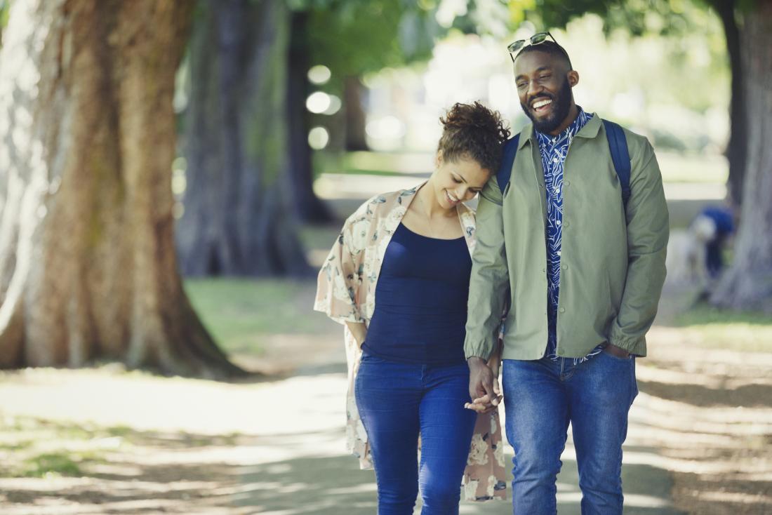 Loving couple holding hands and walking in park