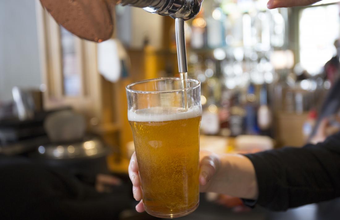 Person pouring beer from tap into beer glass