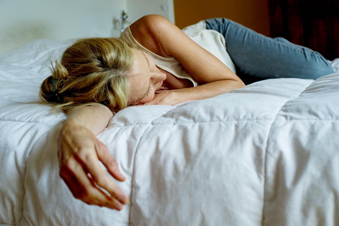 Woman lying on a bed suffering from orgasmic dysfunction