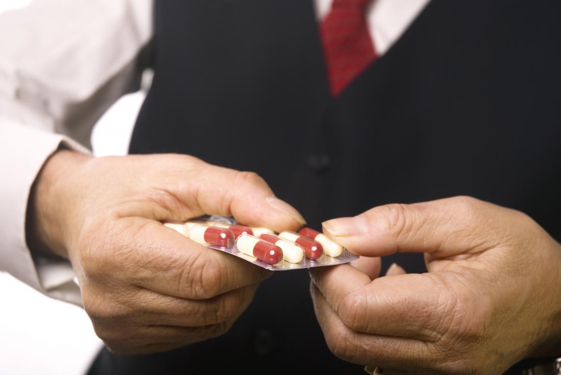 man holding packet of tablets