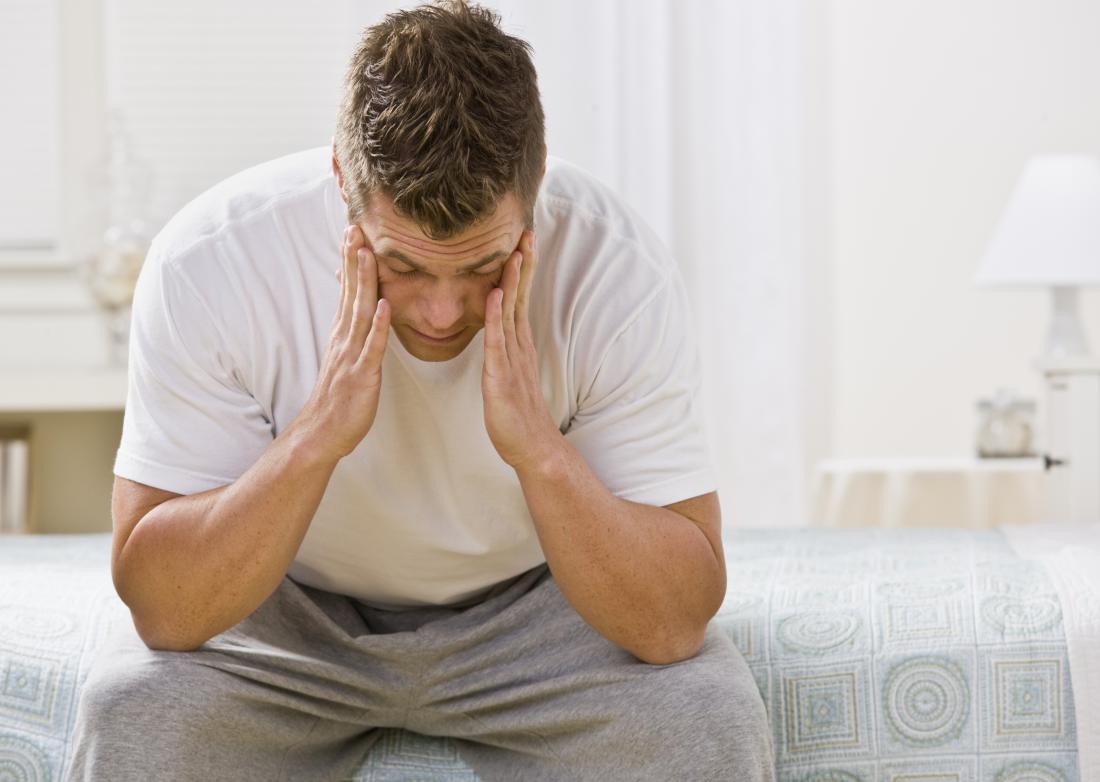 worried young man sitting on bed