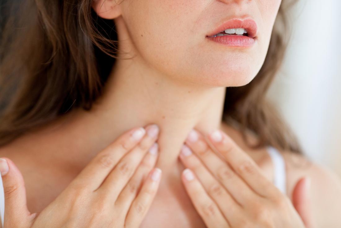 Woman holding neck or throat